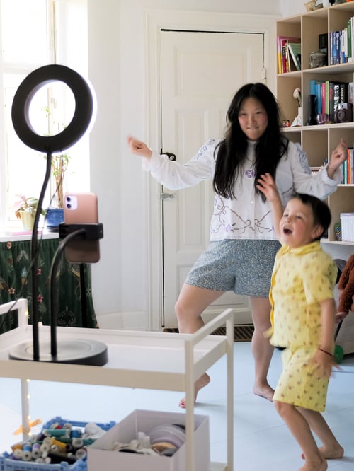 A mother and child dance in front of a smart phone in a LÅNESPELARE ring light with phone holder.