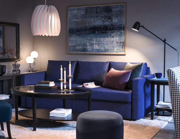 En blå 3-personers FRIHETEN sofa står i en stue.