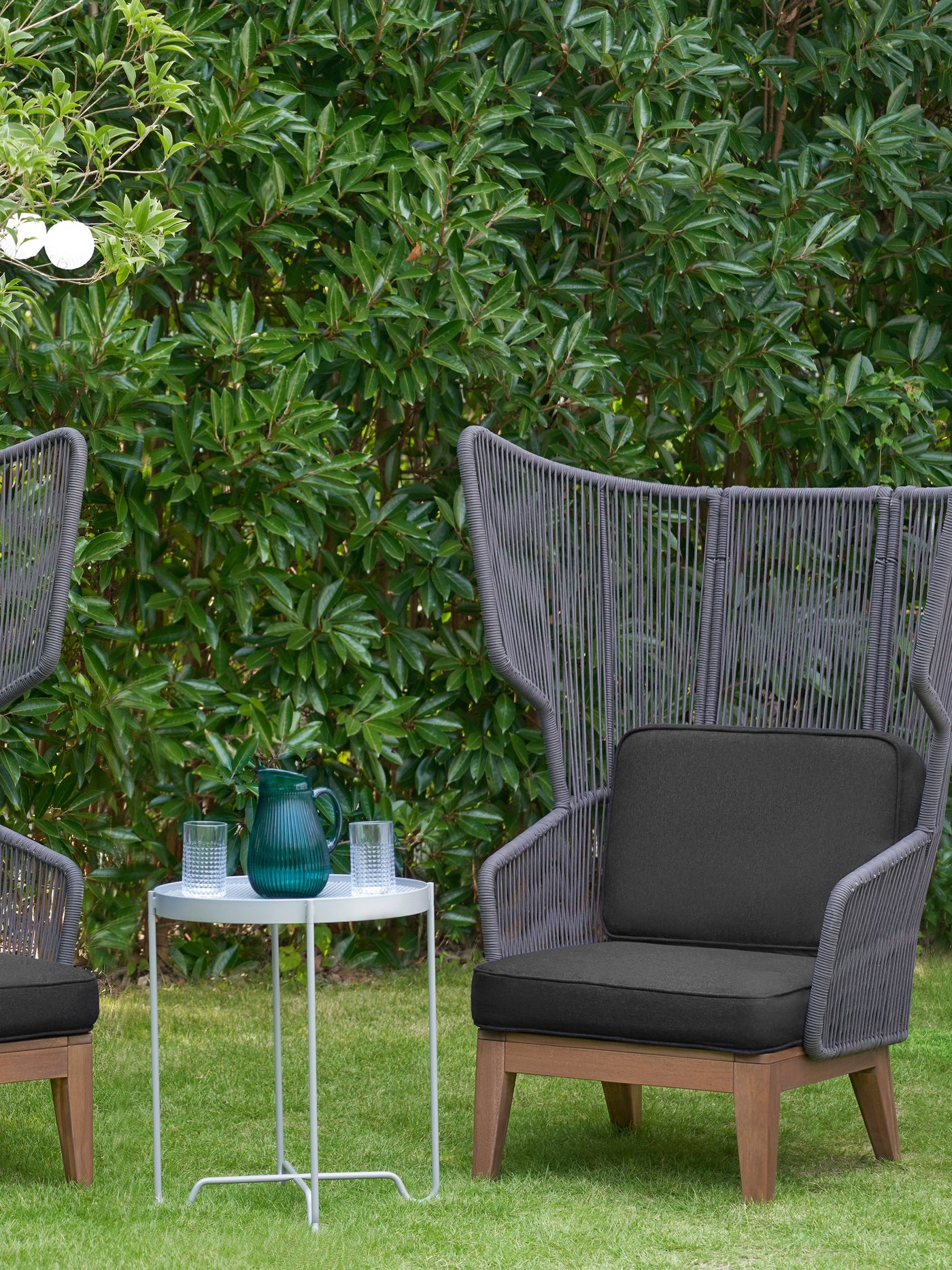 Zwei graue VINGSÖN Ohrensessel stehen im Garten