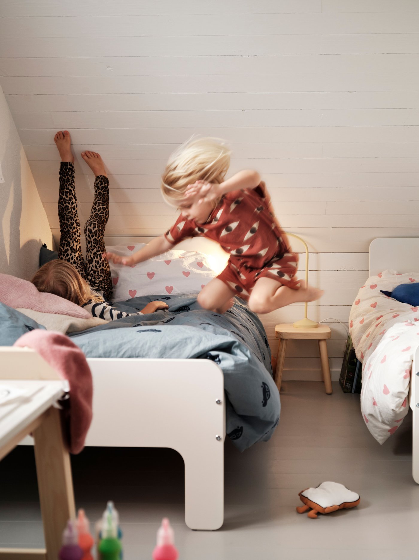 A white SLÄKT ext bed frame with slatted bed base