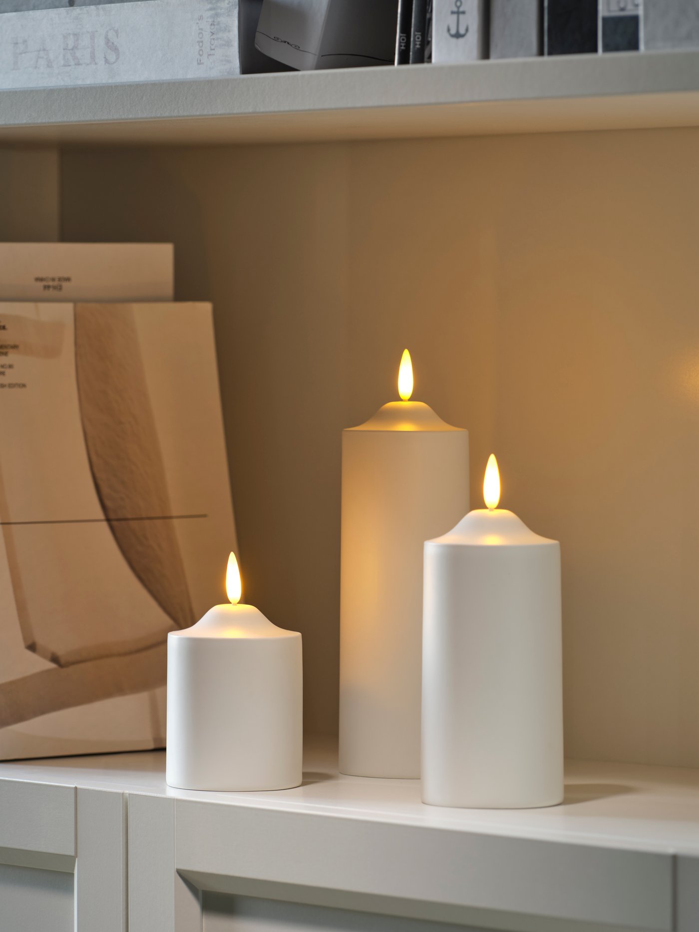 A battery-operated white SMÅLOM LED pillar candle