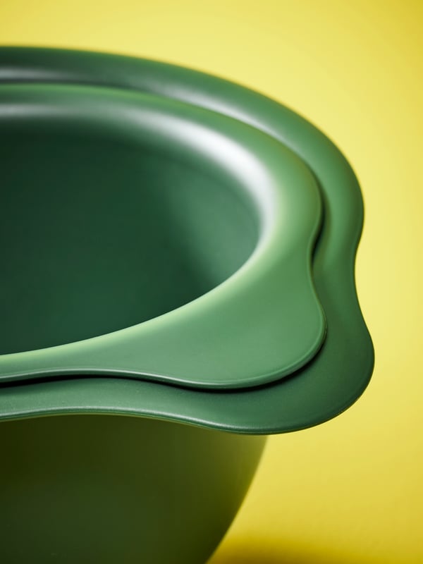 Two stacked dark green VISPAD mixing bowls on a bright yellow background.