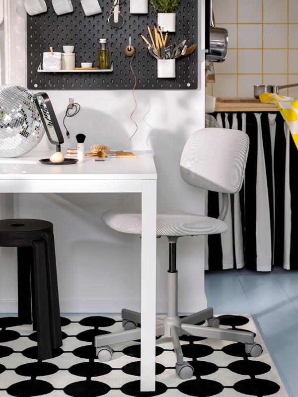 A BLECKBERGET swivel chair stands at a VIHALS extendable table which has a LINDBYN table mirror and a disco ball on top.