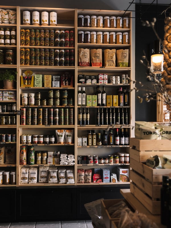 Butikshylla av IVAR skåp med burkar, flaskor och förpackningar – ett välorganiserat utbud av kryddor, oljor och skafferivaror.