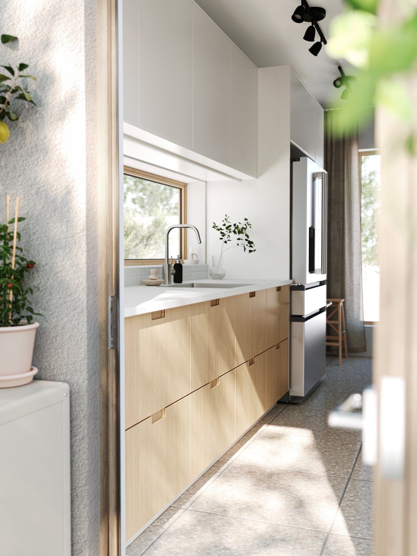 Öppen altandörr leder in till ett kök med stengolv, FÖRJERED luckor nertill och VEDDINGE luckor upptill.