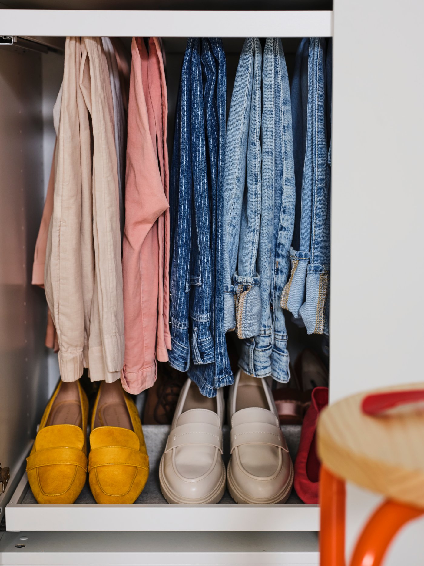An orange/pine DOMSTEN stool in the bedroom