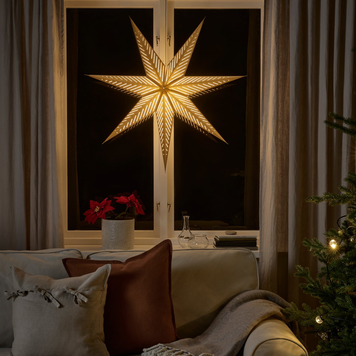 Décoration lumineuse accrochée à une fenêtre de salon.