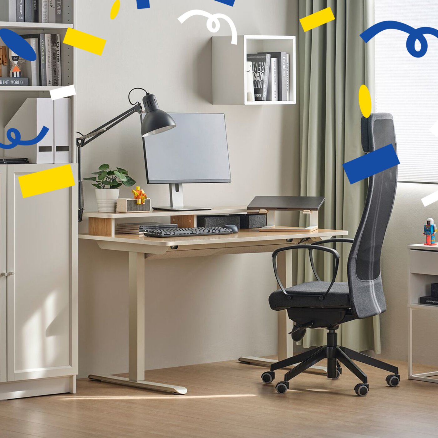 Ein dunkelgrauer MARKUS Bürostuhl (Bezug: Vissle) im Homeoffice. Von oben flieben blauen, weiße und gelbe Konfetti herunter.