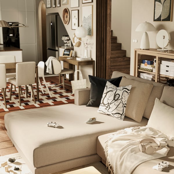 A TONSTAD cabinet with sliding glass doors stands behind a brown-beige UPPÅKRA 3-seat modular sofa with chaise longue.