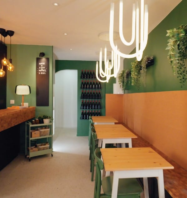 3 tables avec chaises et banc dans un restaurant avec 3 suspensions VARMBLIXT.