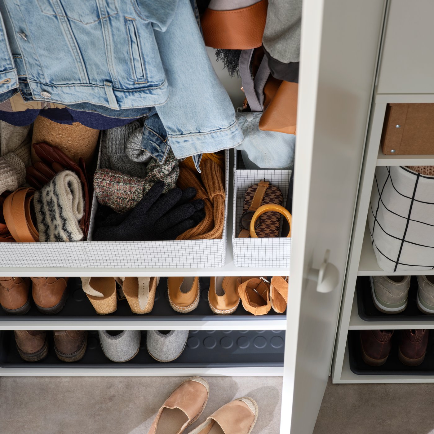 Section d’armoire-penderie ouverte contenant un rangement à compartiments STUK utilisé pour organiser des vêtements et de petits accessoires.