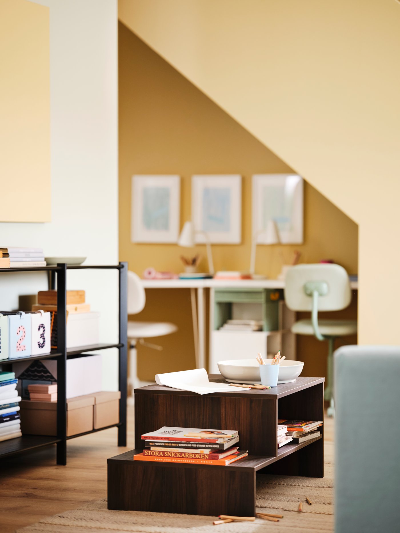 طاولة قهوة HOLMERUD في منتصف غرفة جلوس بالقرب من ركن للمذاكرة أسفل السلالم.