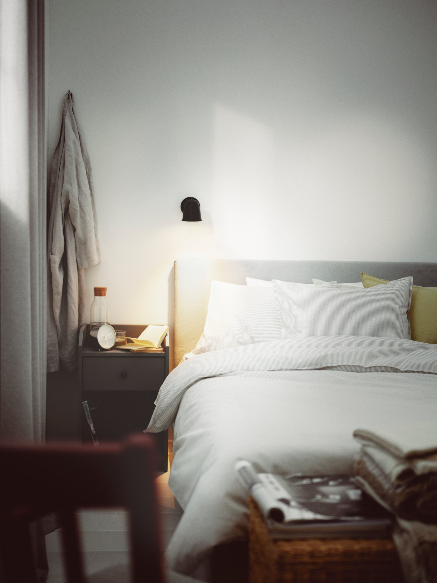 Dormitorio con una cama tapizada GLADSTAD gris con 4 cajones de almacenaje cubierta con una funda nórdica BERGPALM con 2 fundas de almohada.