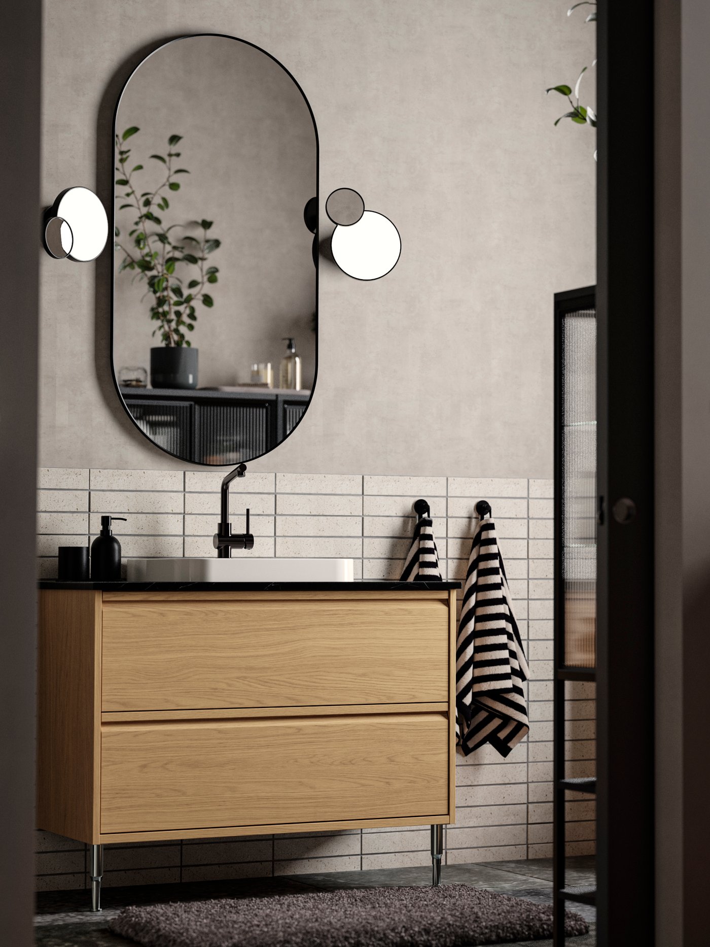 Un tocador de BACKSJÖN baño efecto roble/efecto mármol negro con cajones, fregadero y grifo.