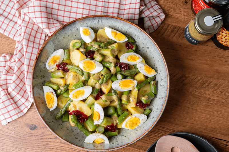 Schwedischer Spargel-Salat mit Kartoffeln und Ei in einer Schüssel, die auf einer Küchentheke steht.