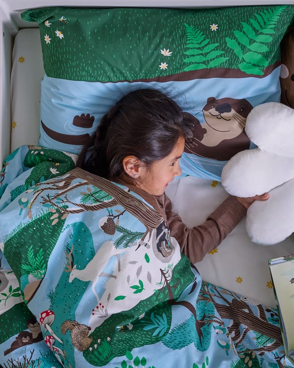A blue green/forest pattern SKOGSDUVA duvet cover and pillowcase in the childrens room