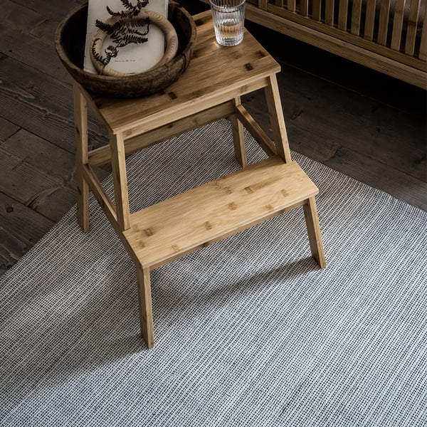 A bamboo TENHULT step stool in the bedroom
