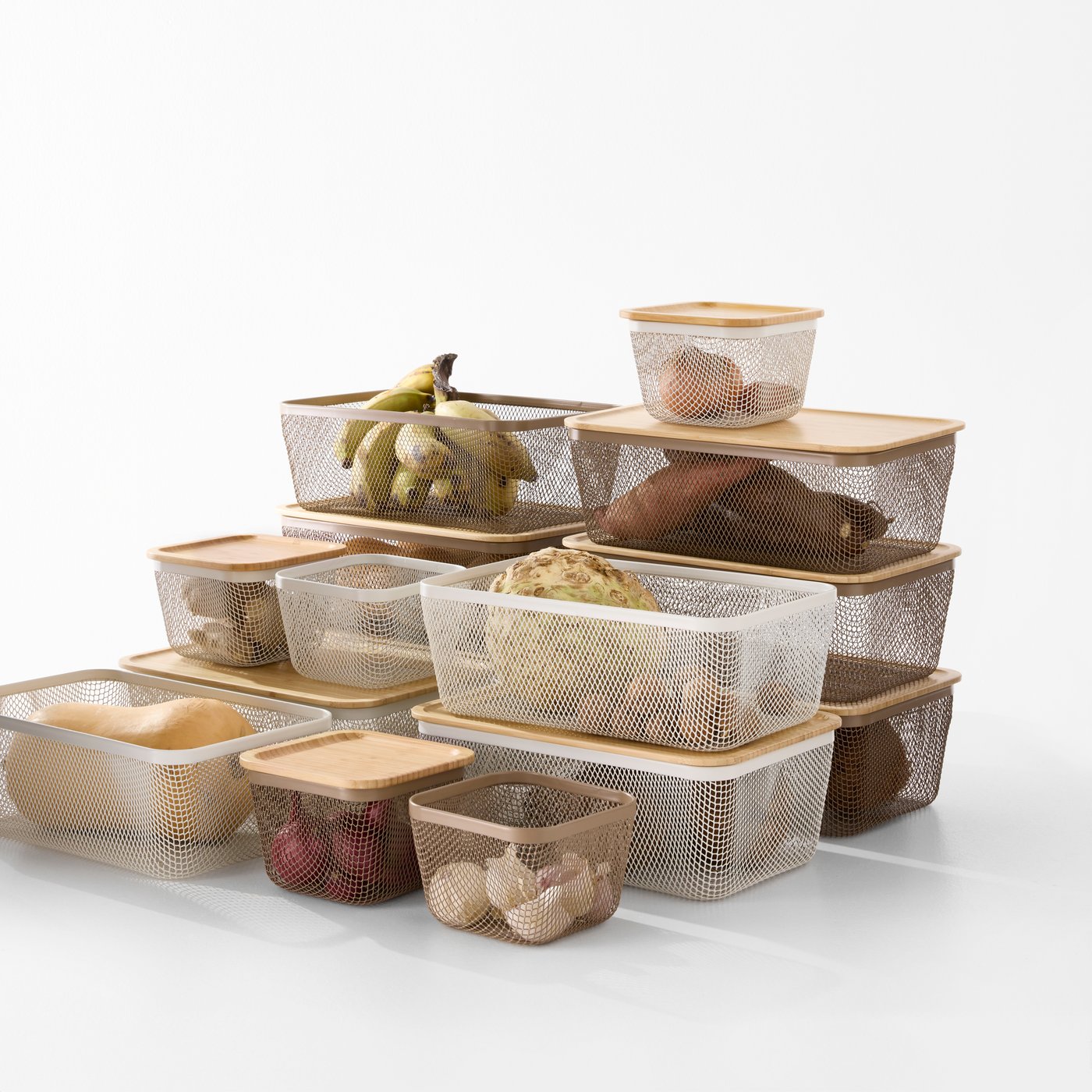 A white background with stacked transparent IKEA 365+ food storage baskets in white made from metal, containing various foods.