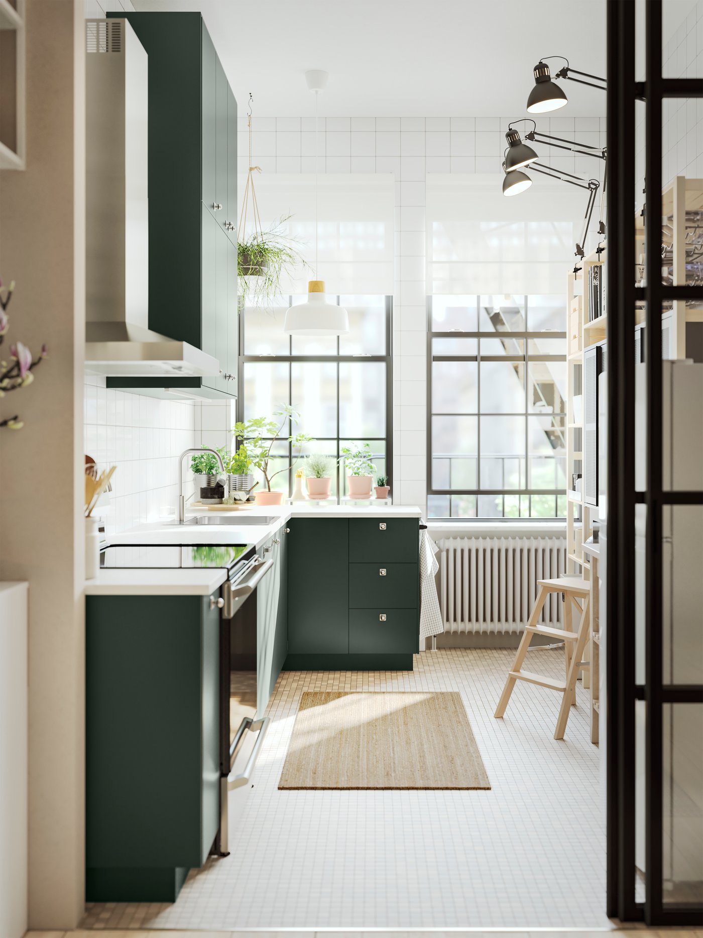 Une cuisine avec des façades vert foncé, un plan de travail EKBACKEN effet marbre blanc/stratifié et une suspension blanc/bouleau.
