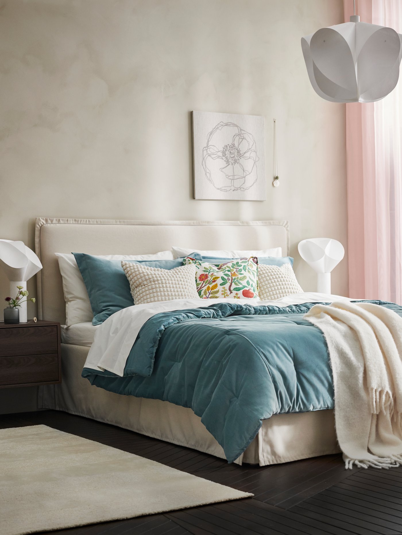 A TÄRNKULLEN bed with SANELA comforter and cushions and a white KLIPPOXEL throw. White BÄCKNATE lamps on the bedside tables.