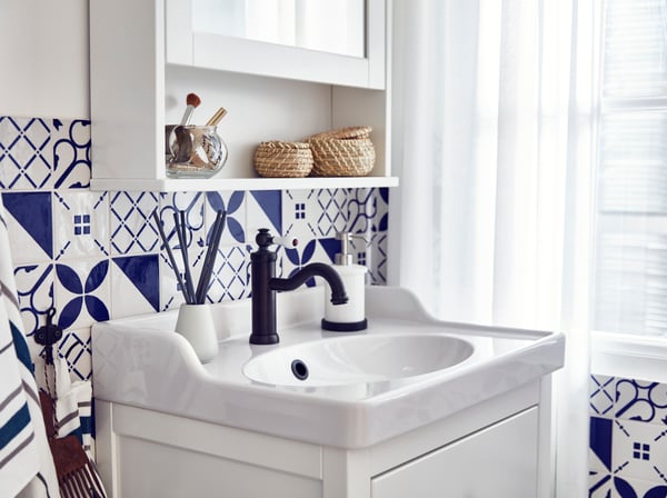 Biała szafka pod umywalkę IKEA HEMNES/RÄTTVIKEN z gładko domykającymi się szufladami z amortyzatorem, w łazience z białymi i niebieskimi płytkami.