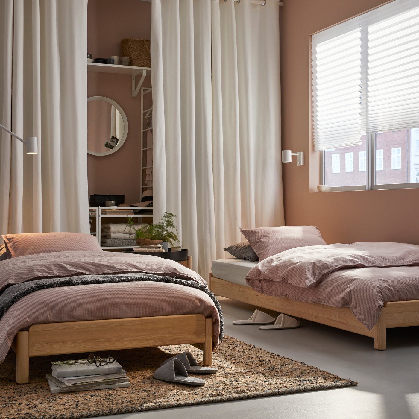 A white NYMÅNE wall/reading lamp in the bedroom