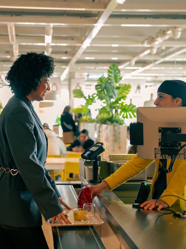Shadia talking to a co-worker by the IKEA stores restaurant check-out.