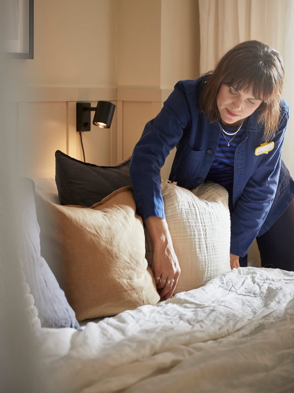 Bild på IKEA inredaren Ida Haginge som bäddar sängen.
