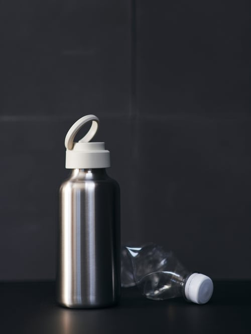 Concentrarea tradițională și minimalistă a unei sticle de apă gri metalic cu un capac alb din plastic polipropilen.