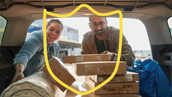 Couple putting their IKEA purchases in the back of a car