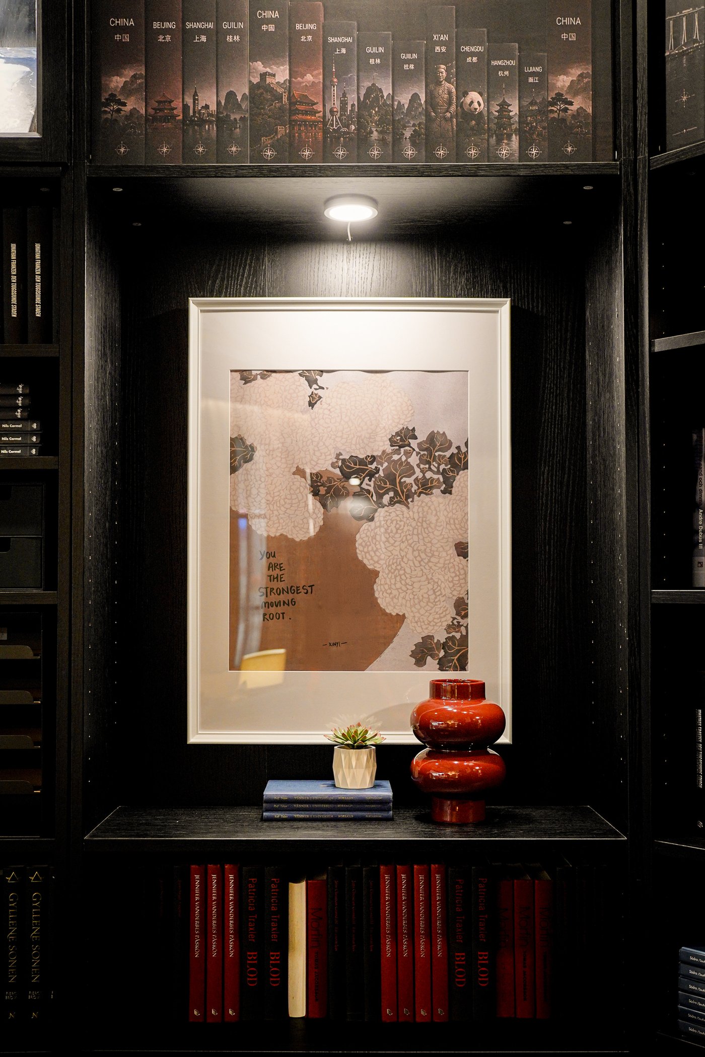 Curious Library room setting at IKEA Tampines, featuring a white KNOPPÄNG frame within a shelf of a black oak effect BILLY bookcase