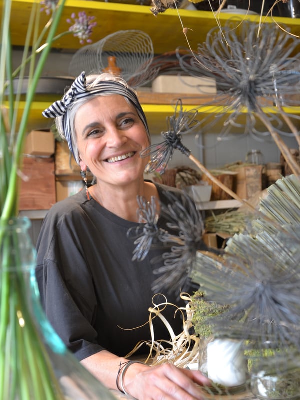 Laura poserer bag en af sine dekorationer med tørrede blomster.
