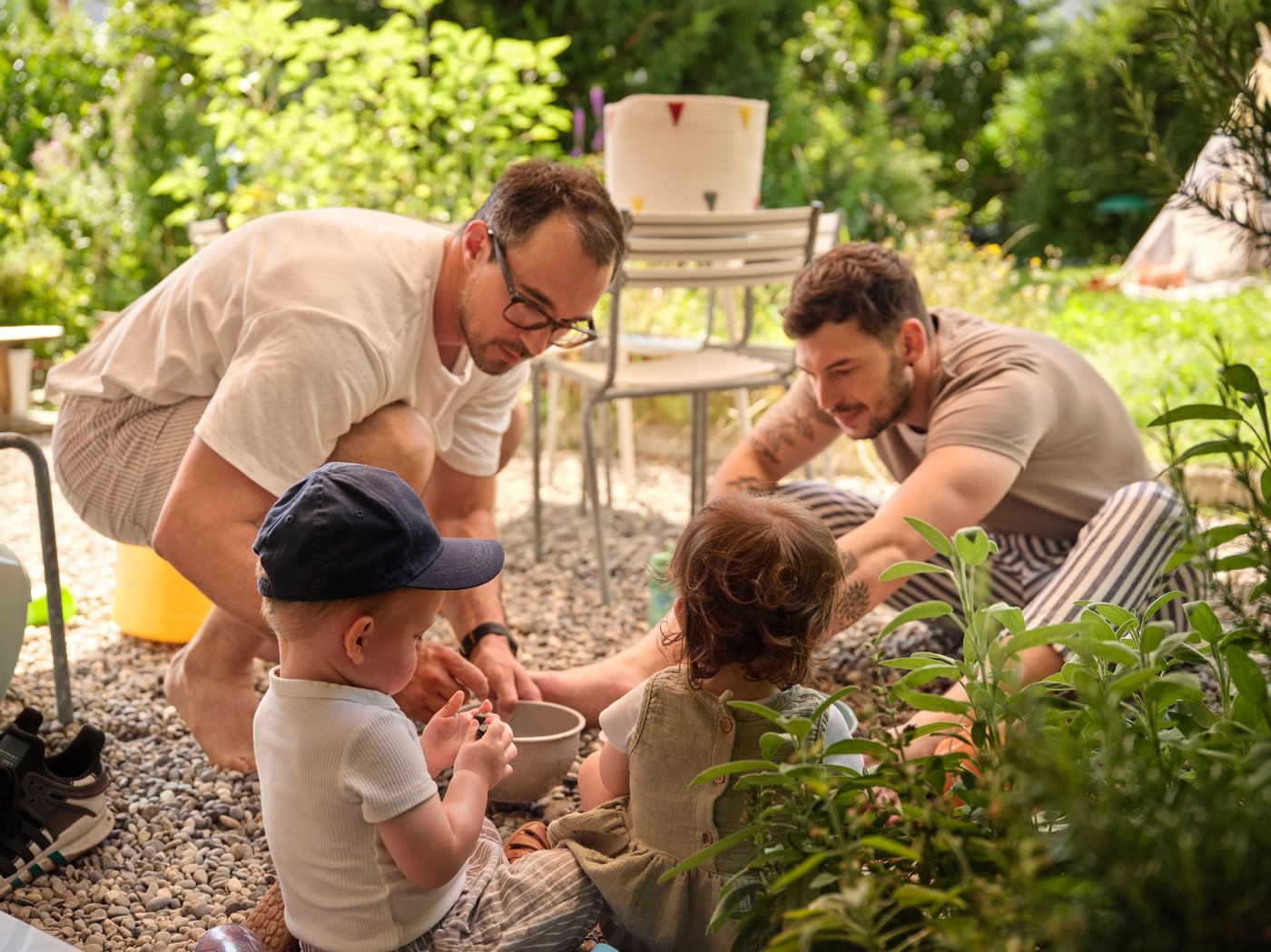 Two men are playing outside with their kids