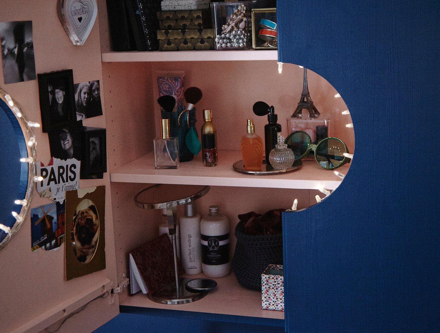 IVAR skab, som er lakeret pink indvendigt og blåt udvendigt, med en udskåret cirkel i midten, så det er blevet til et makeupskab, der både gemmer væk og viser frem.