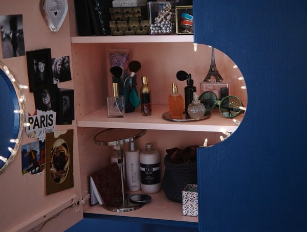 IVAR skab, som er lakeret pink indvendigt og blåt udvendigt, med en udskåret cirkel i midten, så det er blevet til et makeupskab, der både gemmer væk og viser frem.