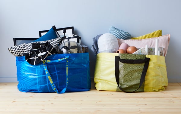 Eine blaue FRAKTA Tasche und eine Grüne IKEA Tasche in denen viele gegenstände verpackt sind.