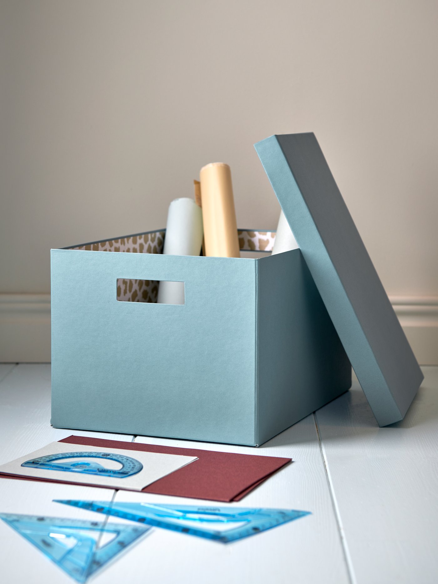 A blue TJENA storage box with lid in the home office