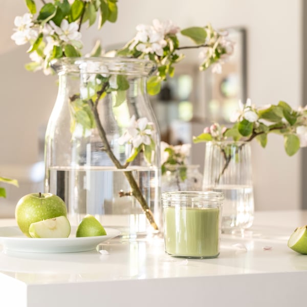 An Apple/light green LÖVSKOGSLUND scented candle in glass