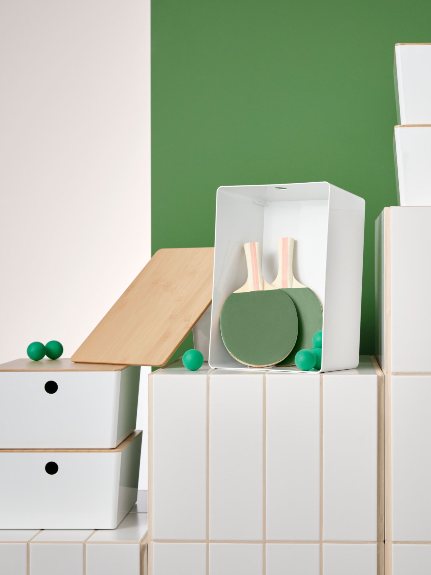 Valkoisilla tasoilla on erikokoisia valkoisia KUGGIS-laatikoita joissa on bambuiset kannet.