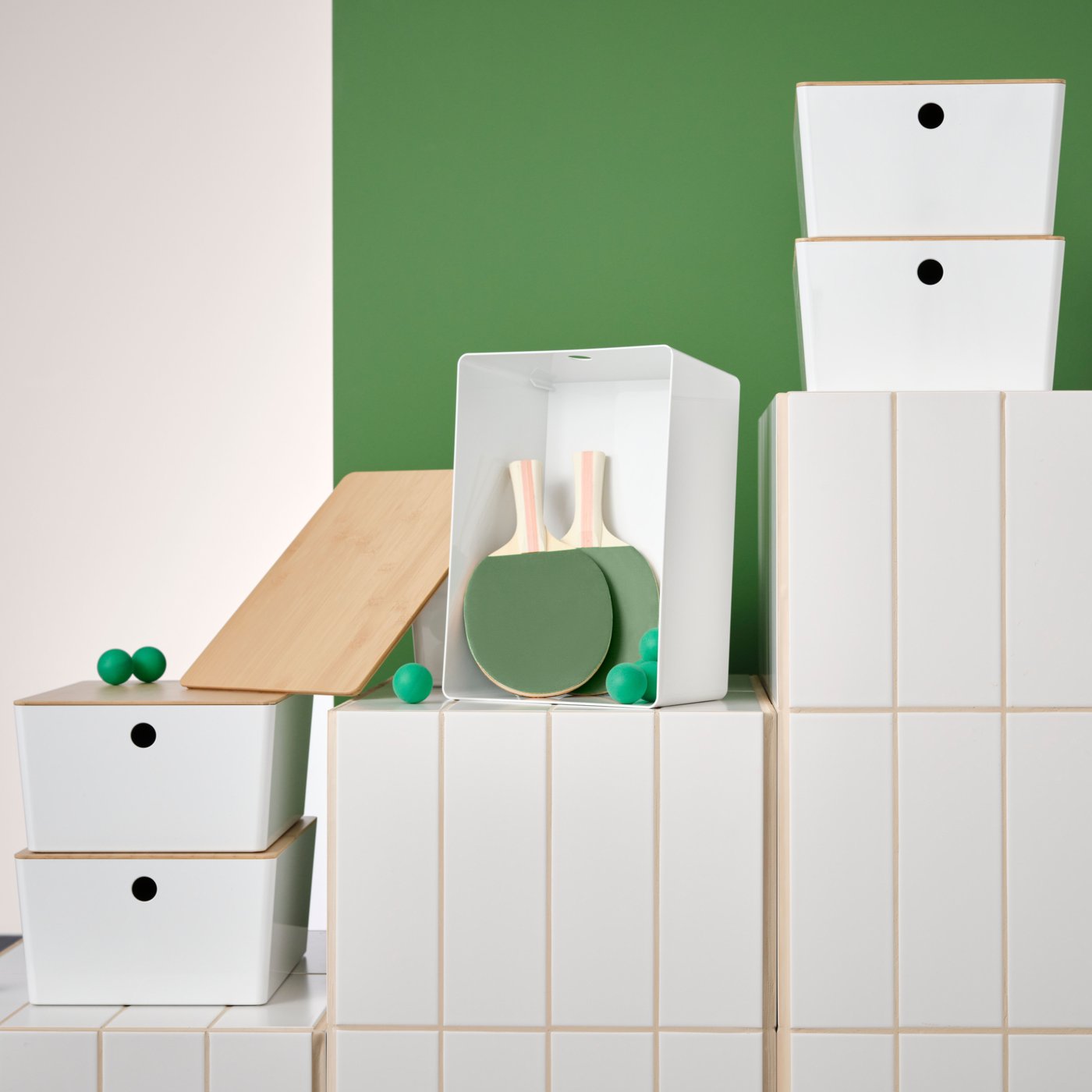 Valkoisilla tasoilla on erikokoisia valkoisia KUGGIS-laatikoita joissa on bambuiset kannet.