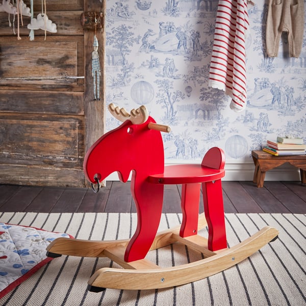 A red/rubberwood EKORRE rocking-moose in the bedroom