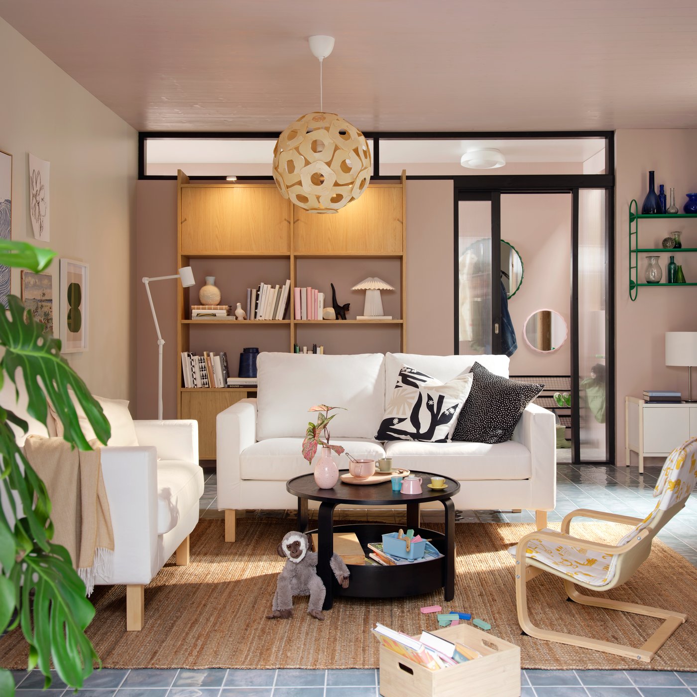 A light living room with a white SALTSJÖBADEN sofa-and armchair combination flanked by a BORGEBY coffee table and toys.