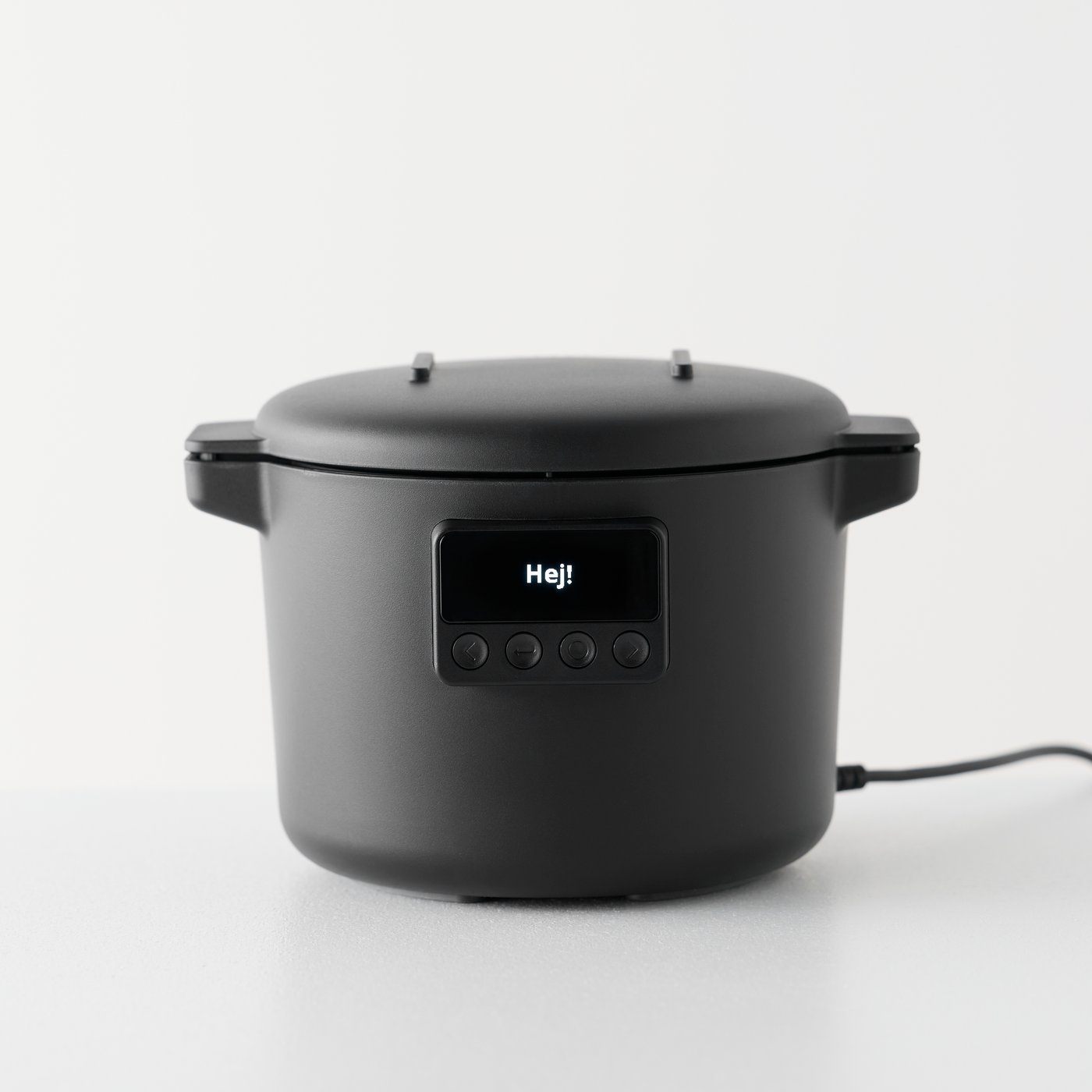 A white background features a black TILLREDA multicooker sitting on a counter with a simple design, cord and control panel.