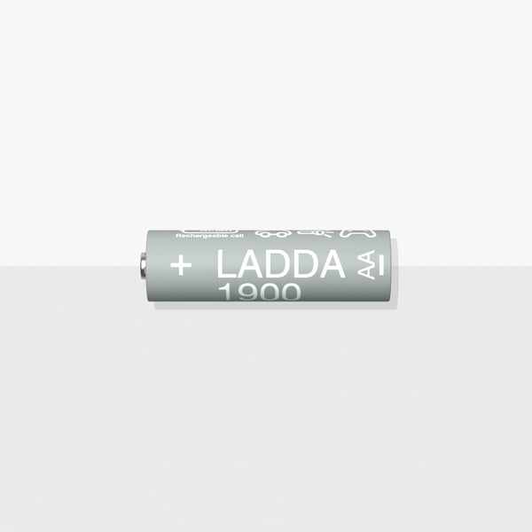 Un primer pla d'una pila recarregable LADDA, HR6 AA, que està damunt d'una superfície blanca i grisa.