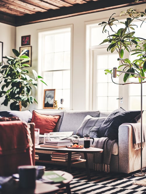 Helles Wohnzimmer mit einem VIMLE 3er-Sofa, einem ULLTISTEL Plaid und einem Kissen einem STORTIMJAN Kissenbezug. Das Sofa steht auf einem STOCKHOLM Teppich.