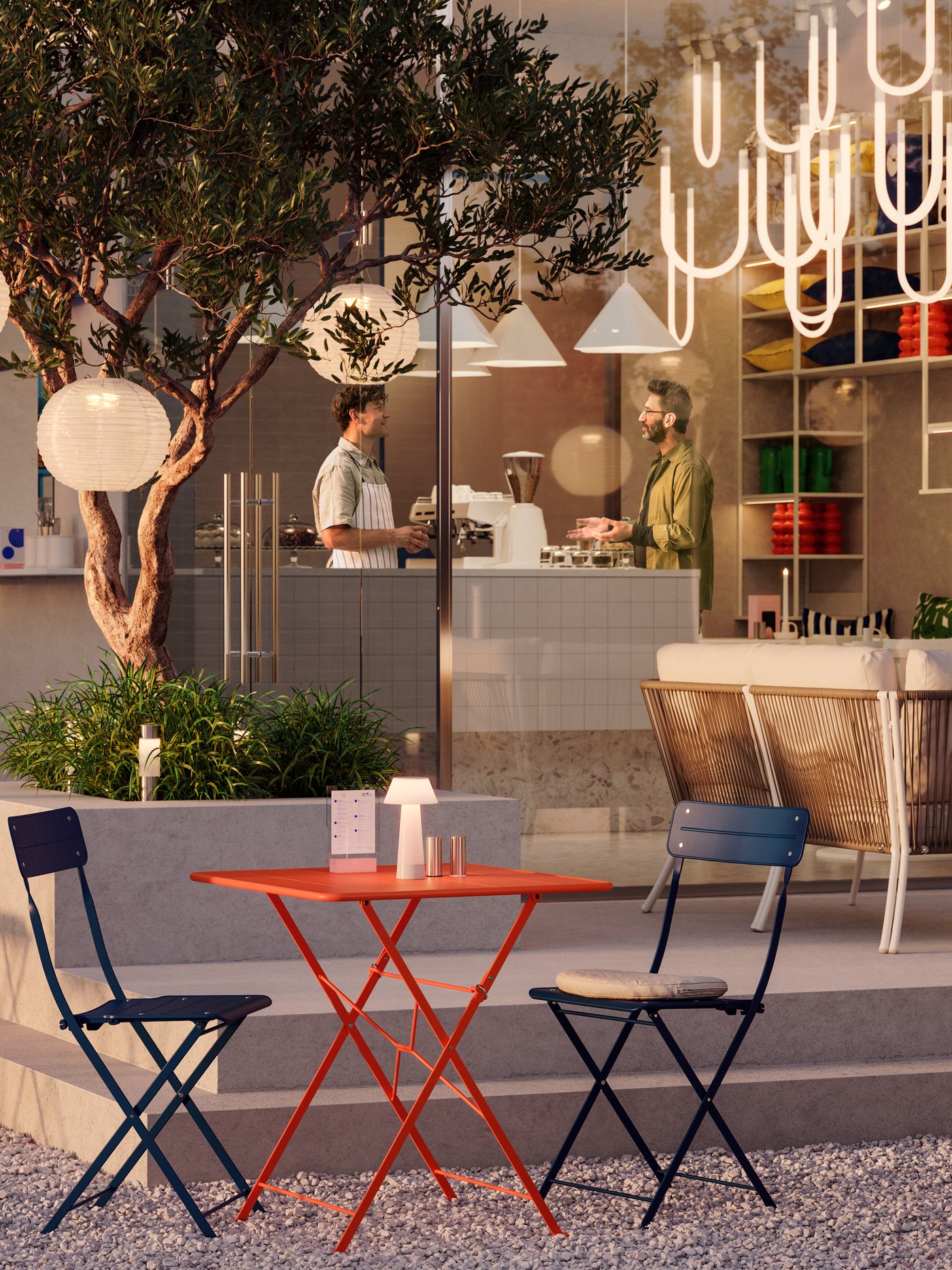 A café with an indoor and an outdoor space with trees, different lamps and SUNDSÖ bistro sets in a warm sunset light.