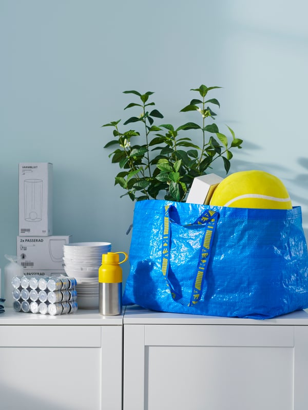 Vreča IKEA na omarici, polna izdelkov IKEA.