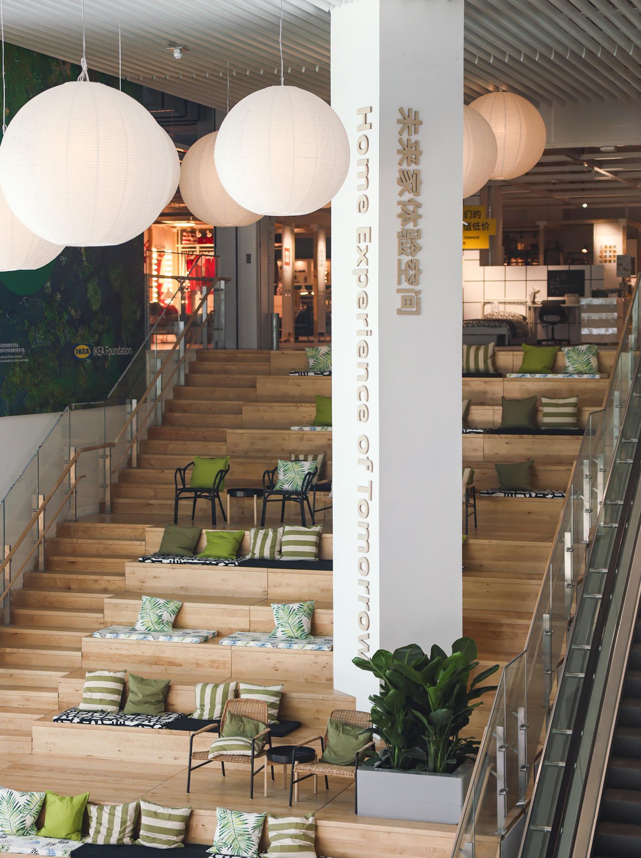 Niz širokih, visokih, stepenastih drvenih sedišta sa šarenim jastucima u IKEA kancelariji.