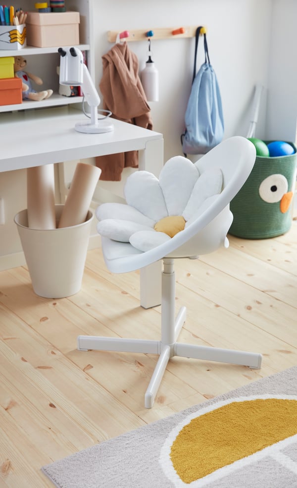 A white PÅHL desk top shelf in the childrens room. White chair with daisy cushion