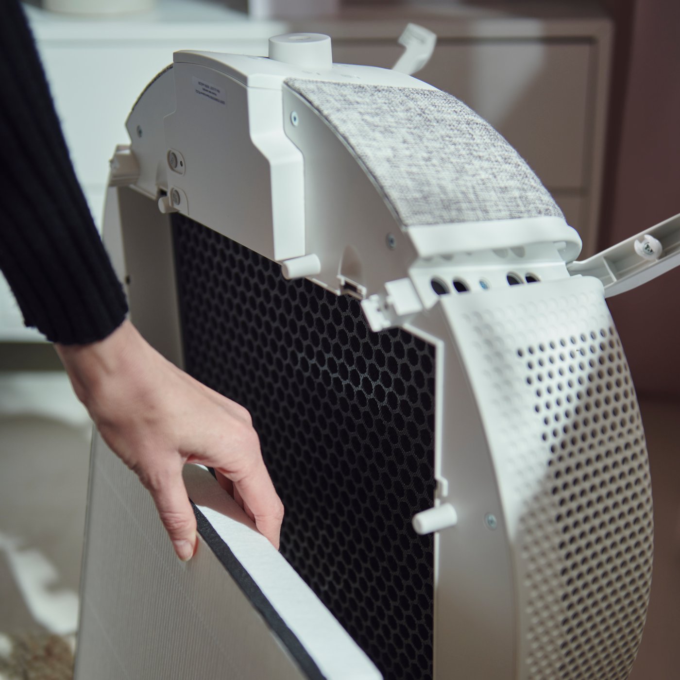 Osoba wymieniająca filt w oczyszczaczu powietrza STARKVIND